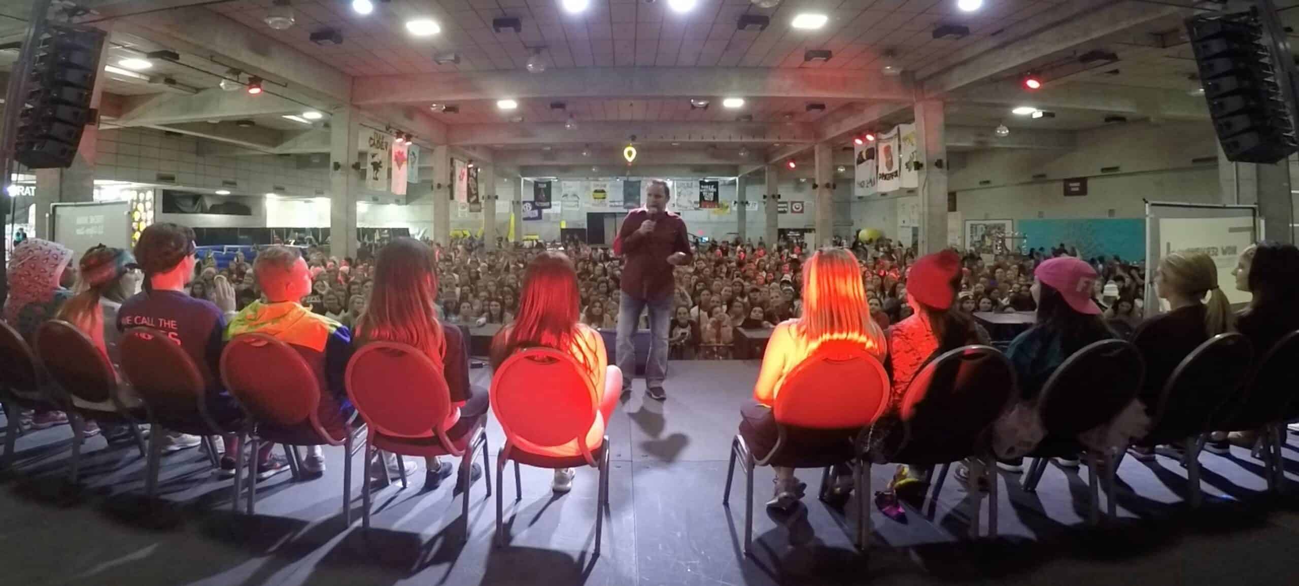 Stage hypnotist Richard Barker performing to a packed indoor audience