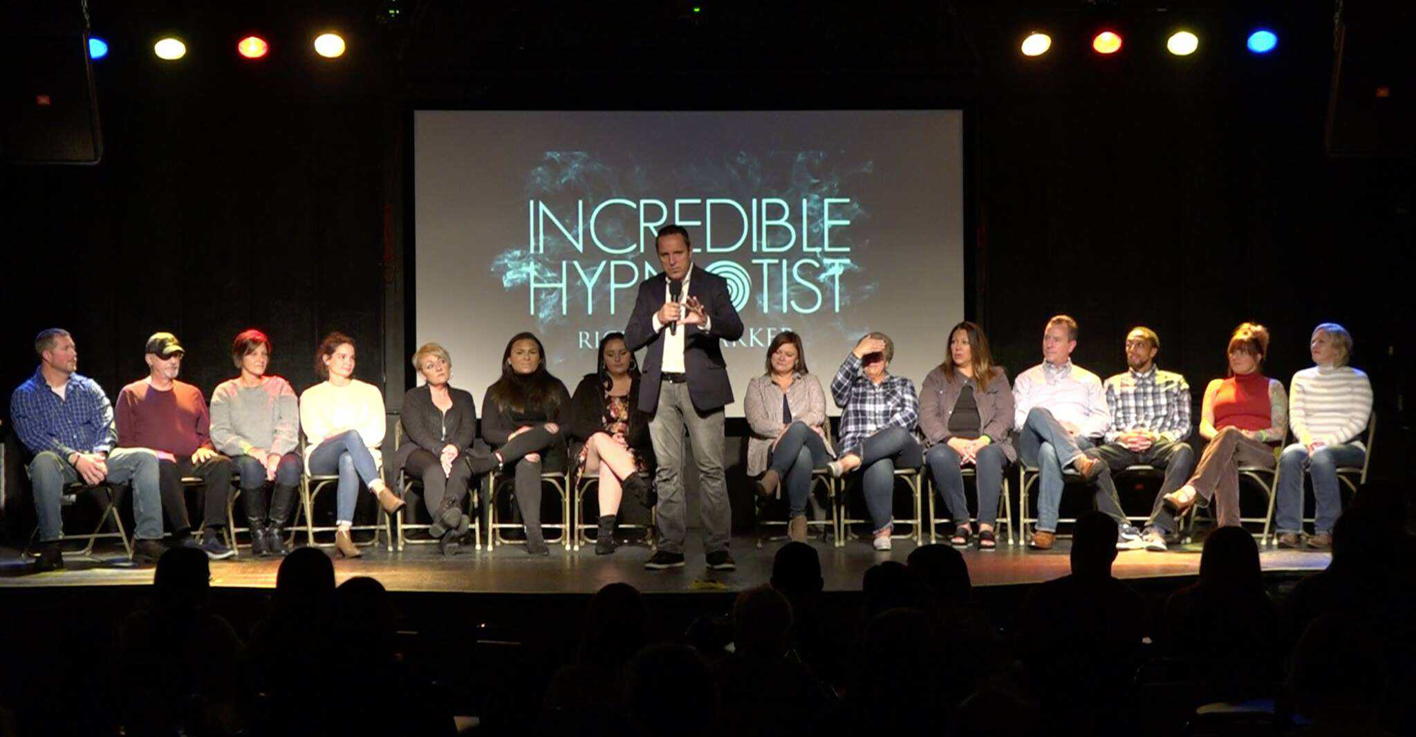 The Incredible Hypnotist Richard Barker on a branded theatre stage with volunteers