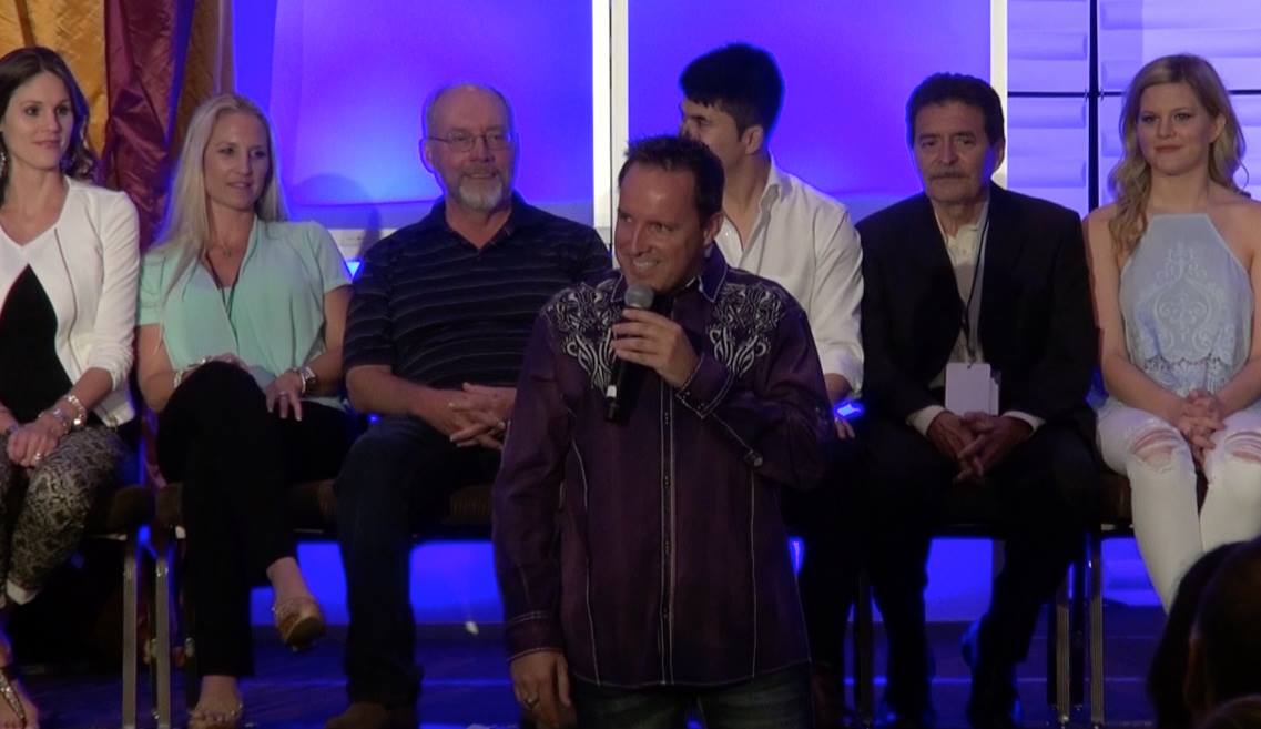 Comedy hypnotist Richard Barker on stage with hypnotized volunteers